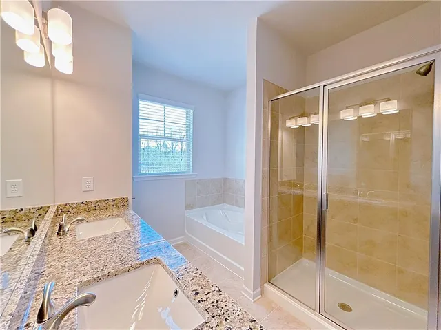 a bathroom with a tub shower and sink