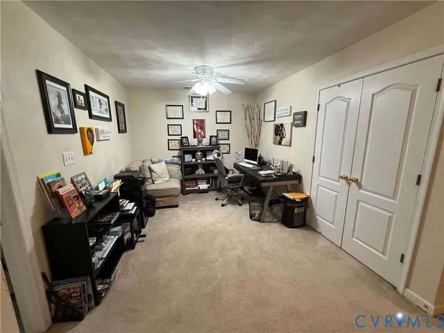 a living room with furniture a couch and a ceiling fan