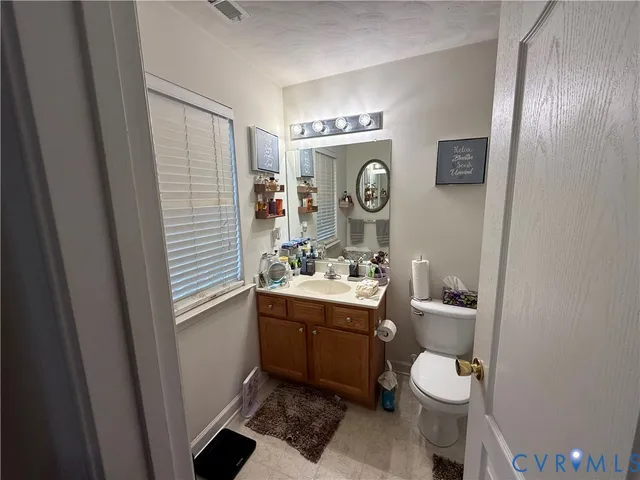 a bathroom with a toilet a sink and a mirror