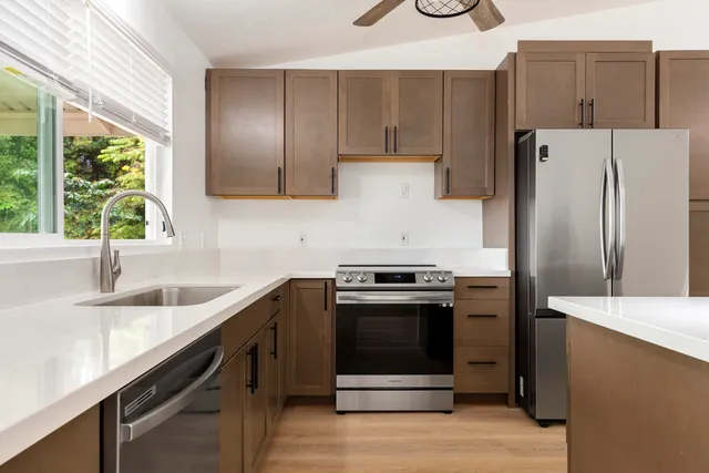 a kitchen with stainless steel appliances granite countertop a sink stove and refrigerator