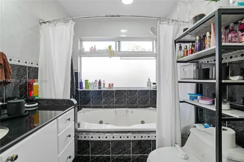 a bathroom with a granite countertop sink a toilet and a bathtub