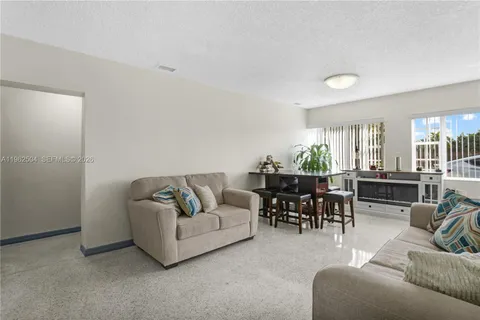 a living room with furniture and a view of kitchen