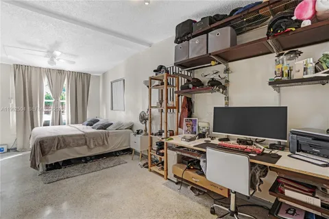 a bedroom with a bed and a computer on the desk