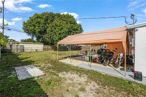 a view of a patio with table and chairs under an umbrella