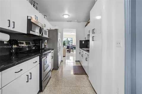 a kitchen with stainless steel appliances granite countertop a refrigerator and a stove top oven