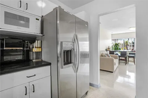 a kitchen with stainless steel appliances granite countertop a refrigerator a stove and a sink