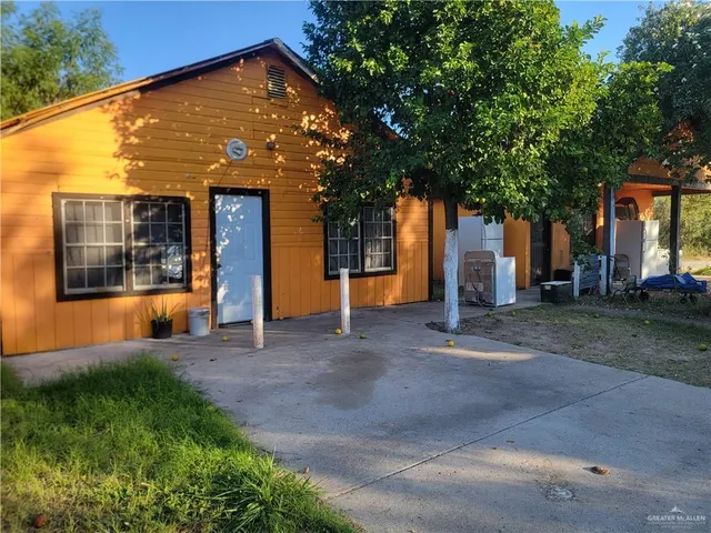 a view of a house with large windows and a small yard