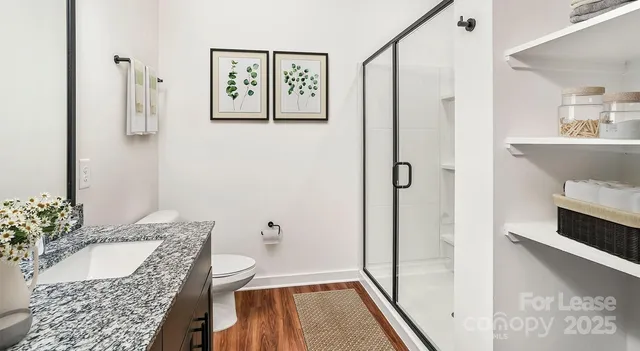 a bathroom with a granite countertop sink a mirror and shower