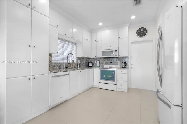 a kitchen with white cabinets and white appliances