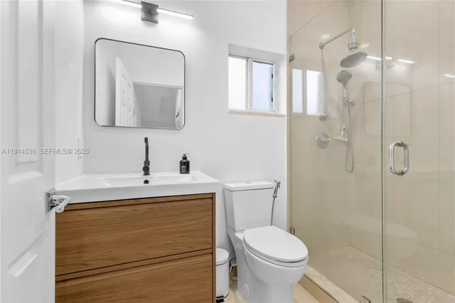 a bathroom with a toilet sink vanity and mirror