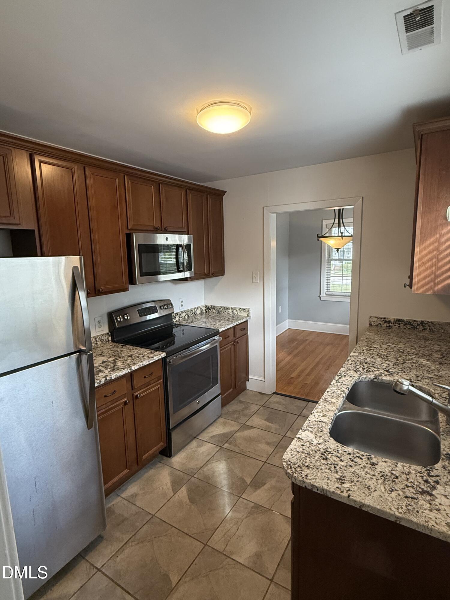 403 Brooks Avenue Raleigh, NC 27607 - Photo 2 of 9 a kitchen with granite countertop a sink a stove top oven a refrigerator and a stove