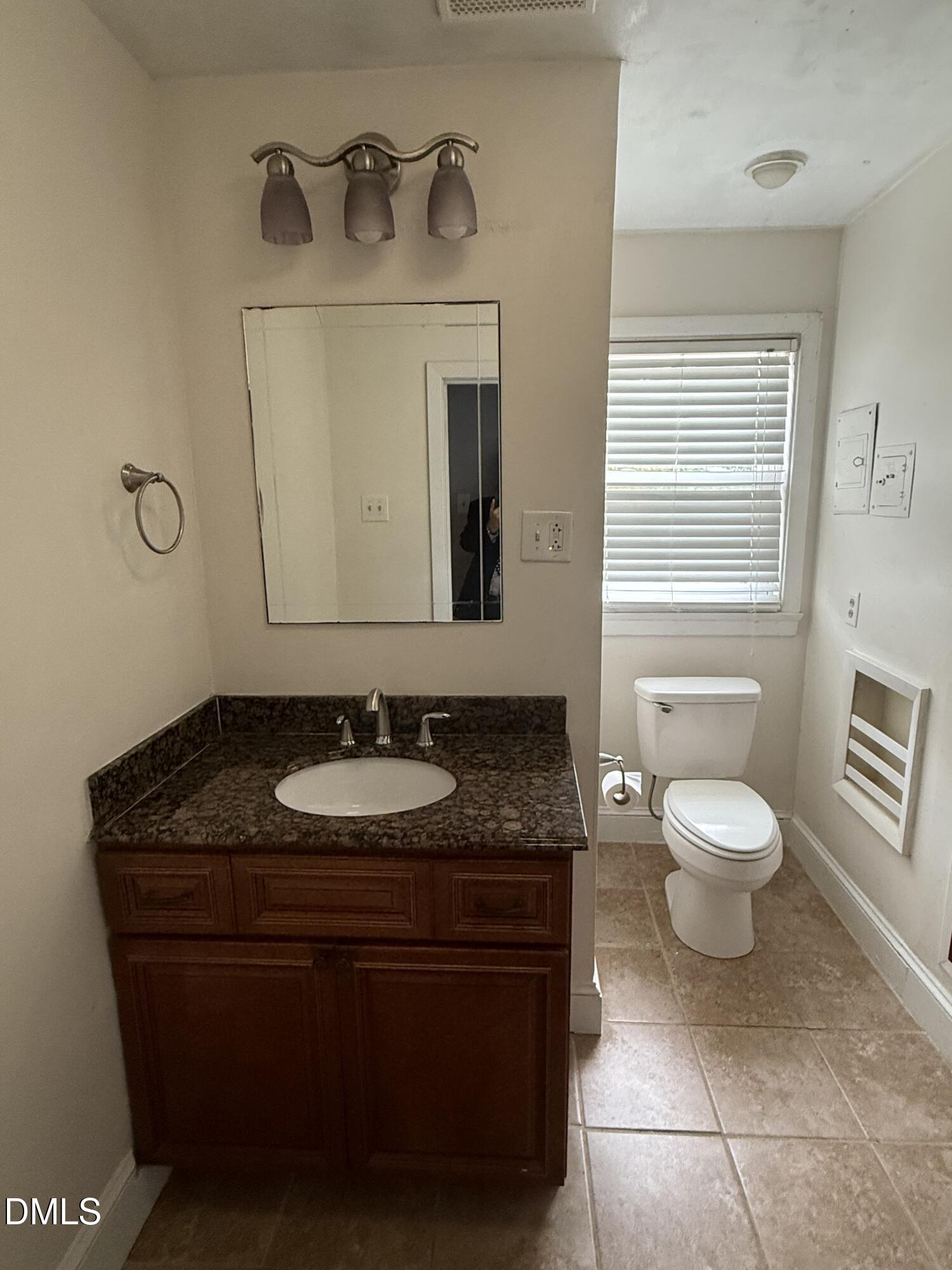 403 Brooks Avenue Raleigh, NC 27607 - Photo 5 of 9 a bathroom with a granite countertop sink a toilet and a mirror