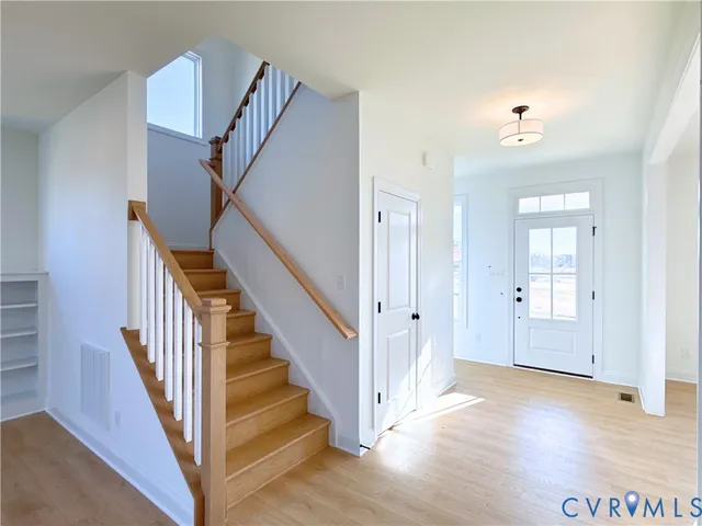 a view of a hallway with wooden floor and entryway