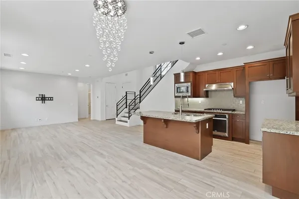 a kitchen with stainless steel appliances granite countertop a stove a refrigerator and a sink
