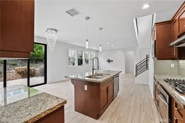 a kitchen with stainless steel appliances granite countertop a stove a sink dishwasher and a refrigerator