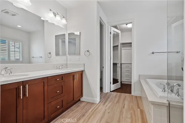 a spacious bathroom with a double vanity sink a large mirror and a shower