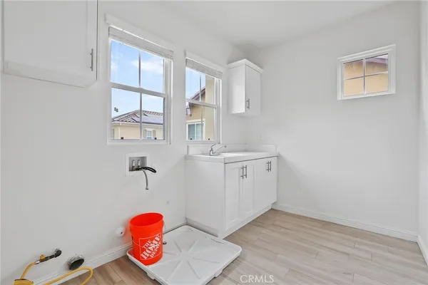 a utility room with sink dryer and washer