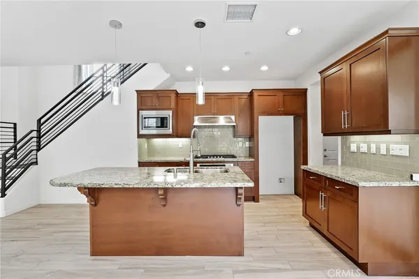 a large kitchen with kitchen island a sink stainless steel appliances and cabinets