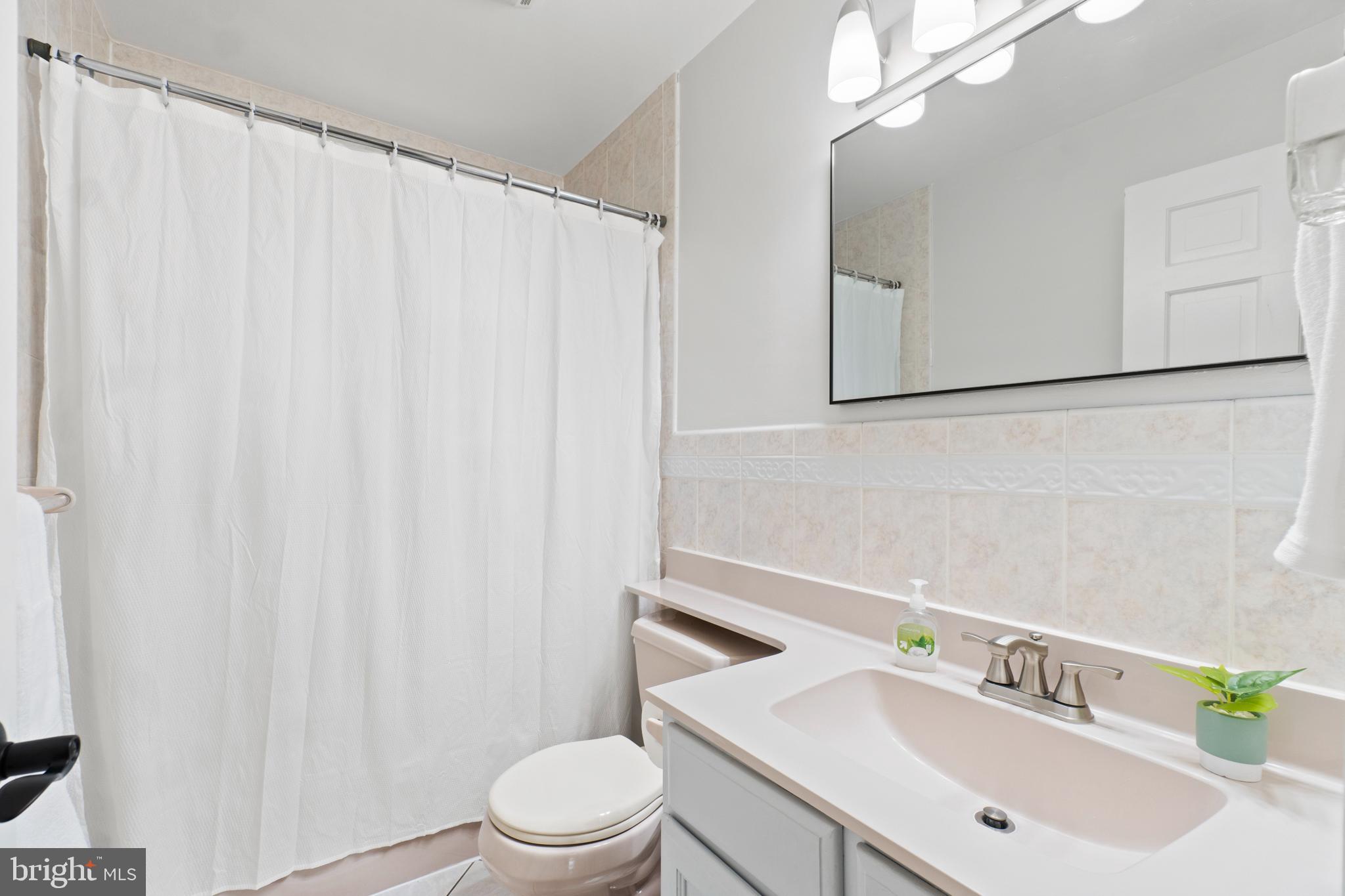 8821 Sundale Drive Silver Spring, MD 20910 - Photo 17 of 27 a bathroom with a sink a toilet and shower curtain