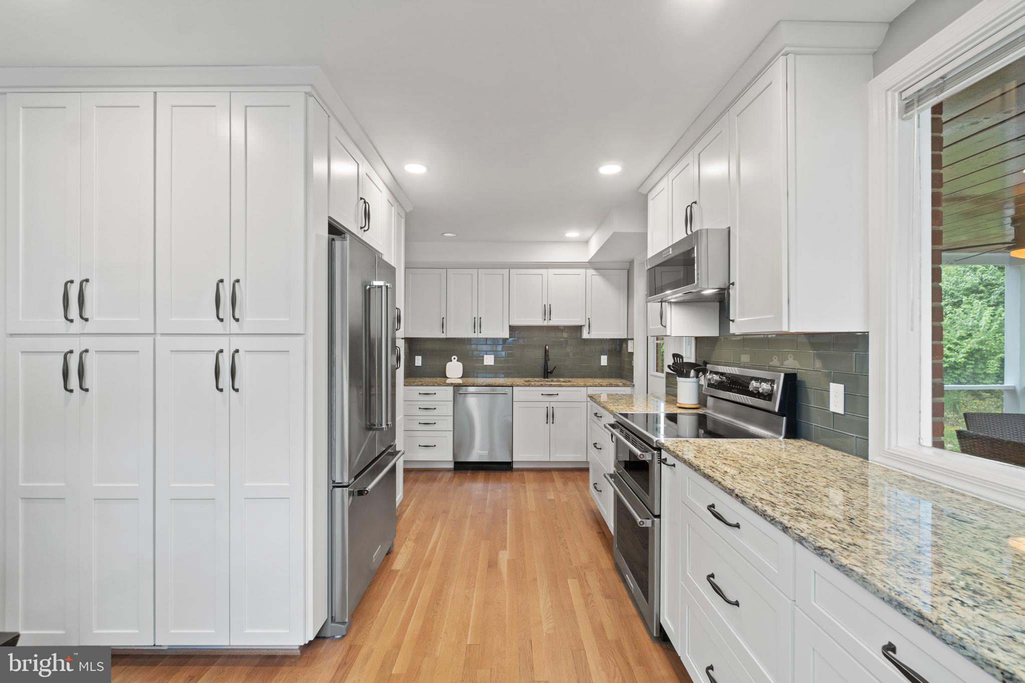 8821 Sundale Drive Silver Spring, MD 20910 - Photo 6 of 27 a kitchen with stainless steel appliances granite countertop refrigerator a sink and white cabinets with wooden floor