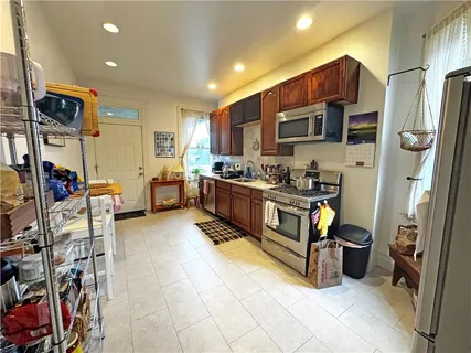 a kitchen with stainless steel appliances a stove a refrigerator and a sink