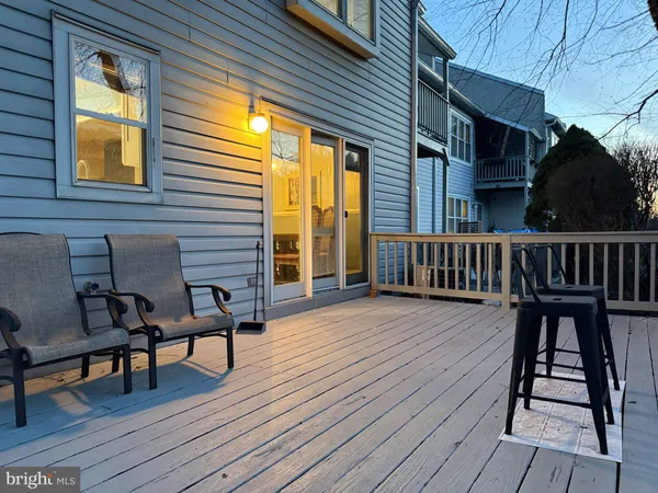 a view of a house with wooden deck and furniture