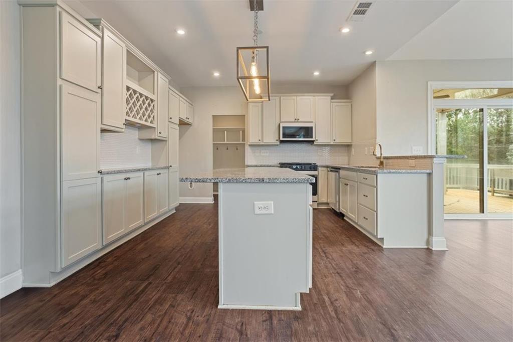 129 Rex Avenue Canton, GA 30114 - Photo 15 of 66 a kitchen with stainless steel appliances granite countertop a sink a stove a refrigerator and island with wooden floor