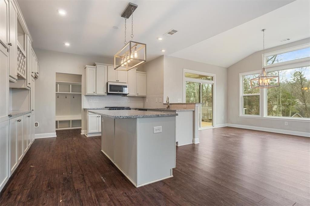 129 Rex Avenue Canton, GA 30114 - Photo 21 of 66 a kitchen with stainless steel appliances granite countertop a stove top oven a sink a refrigerator and white cabinets with wooden floor