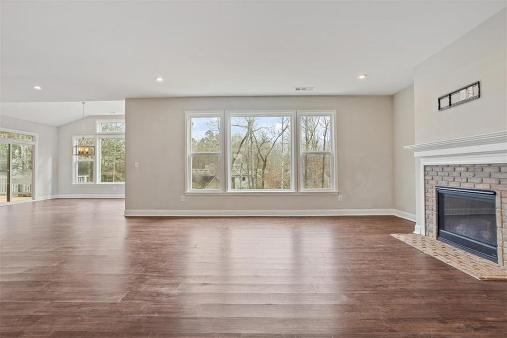 129 Rex Avenue Canton, GA 30114 - Photo 9 of 66 an empty room with wooden floor and a fireplace