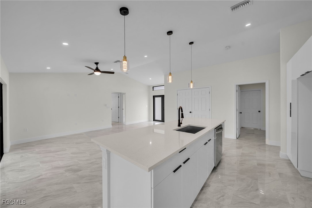 4106 35th Street Southwest Lehigh Acres, FL 33976 - Photo 13 of 38 a kitchen with kitchen island a sink stainless steel appliances and a counter top
