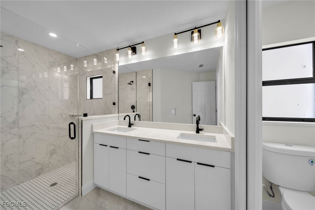 4106 35th Street Southwest Lehigh Acres, FL 33976 - Photo 22 of 38 a bathroom with a double vanity sink mirror and shower