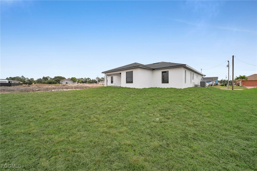 4106 35th Street Southwest Lehigh Acres, FL 33976 - Photo 33 of 38 a view of a house with a yard and garage