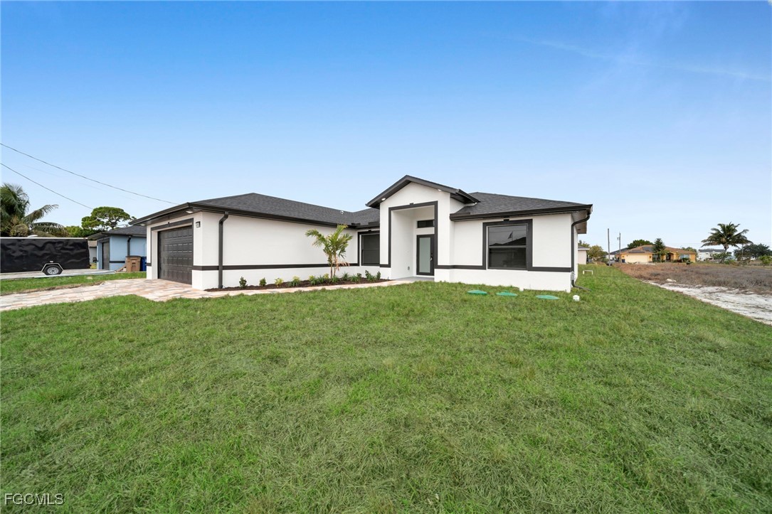 4106 35th Street Southwest Lehigh Acres, FL 33976 - Photo 4 of 38 a front view of a house with a yard and garage