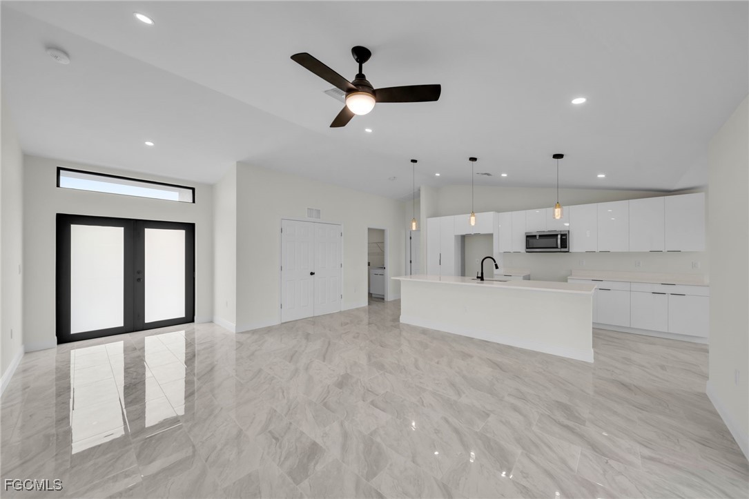 4106 35th Street Southwest Lehigh Acres, FL 33976 - Photo 7 of 38 a living room with stainless steel appliances furniture and a chandelier