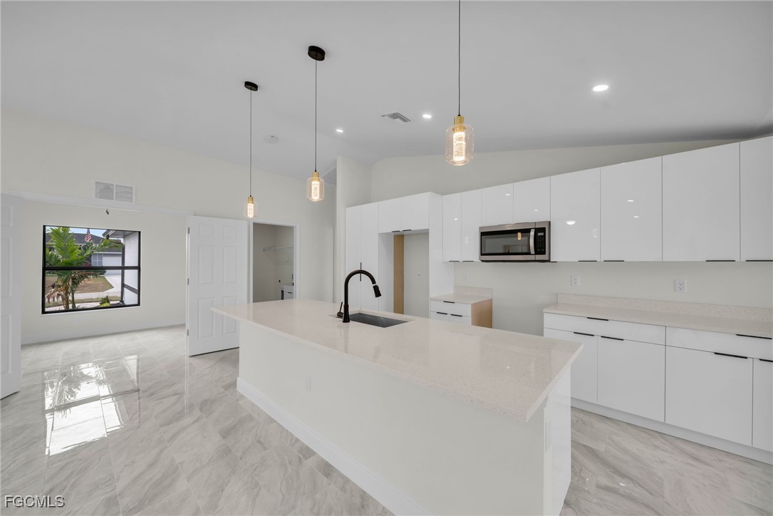 4106 35th Street Southwest Lehigh Acres, FL 33976 - Photo 8 of 38 a large white kitchen with a large window
