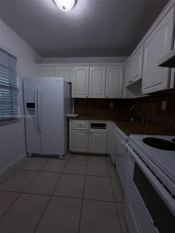 a kitchen with cabinets and white appliances