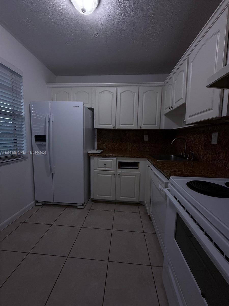 a kitchen with cabinets and white appliances