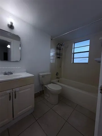 a bathroom with a granite countertop toilet a sink and bathtub