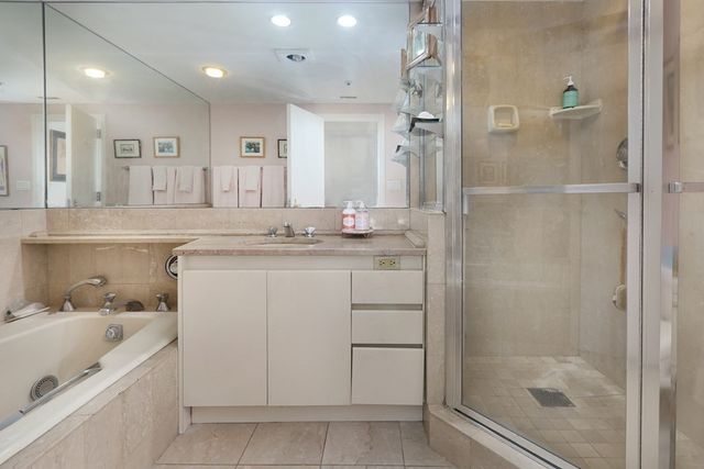 a bathroom with a granite countertop sink mirror and shower
