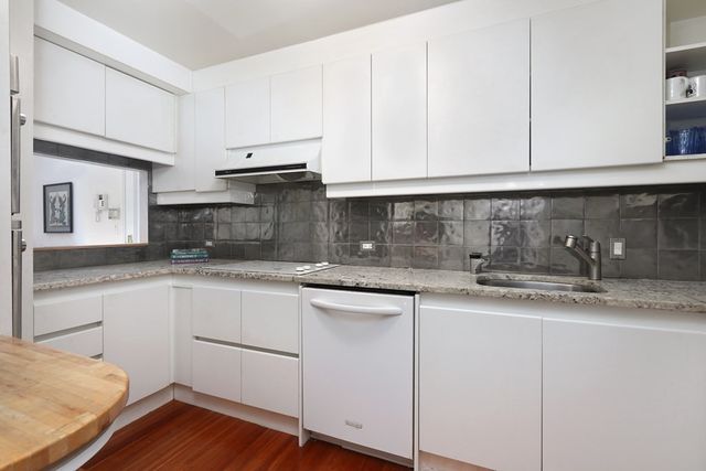 a kitchen with granite countertop white cabinets and white appliances