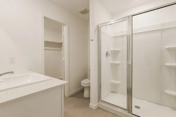 a bathroom with a shower sink vanity and toilet