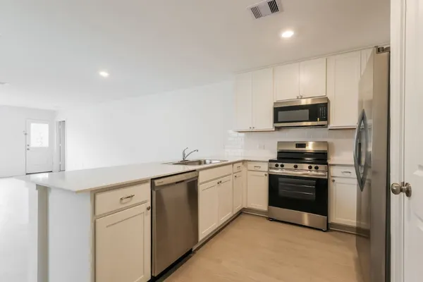 a kitchen with stainless steel appliances granite countertop a stove a sink and a refrigerator