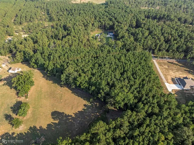 an aerial view of a house with a yard and lake view
