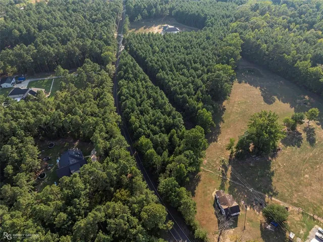 an aerial view of residential house with outdoor space and trees all around