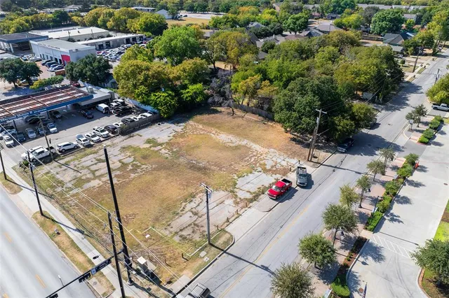a large parking space with lots of trees in the back