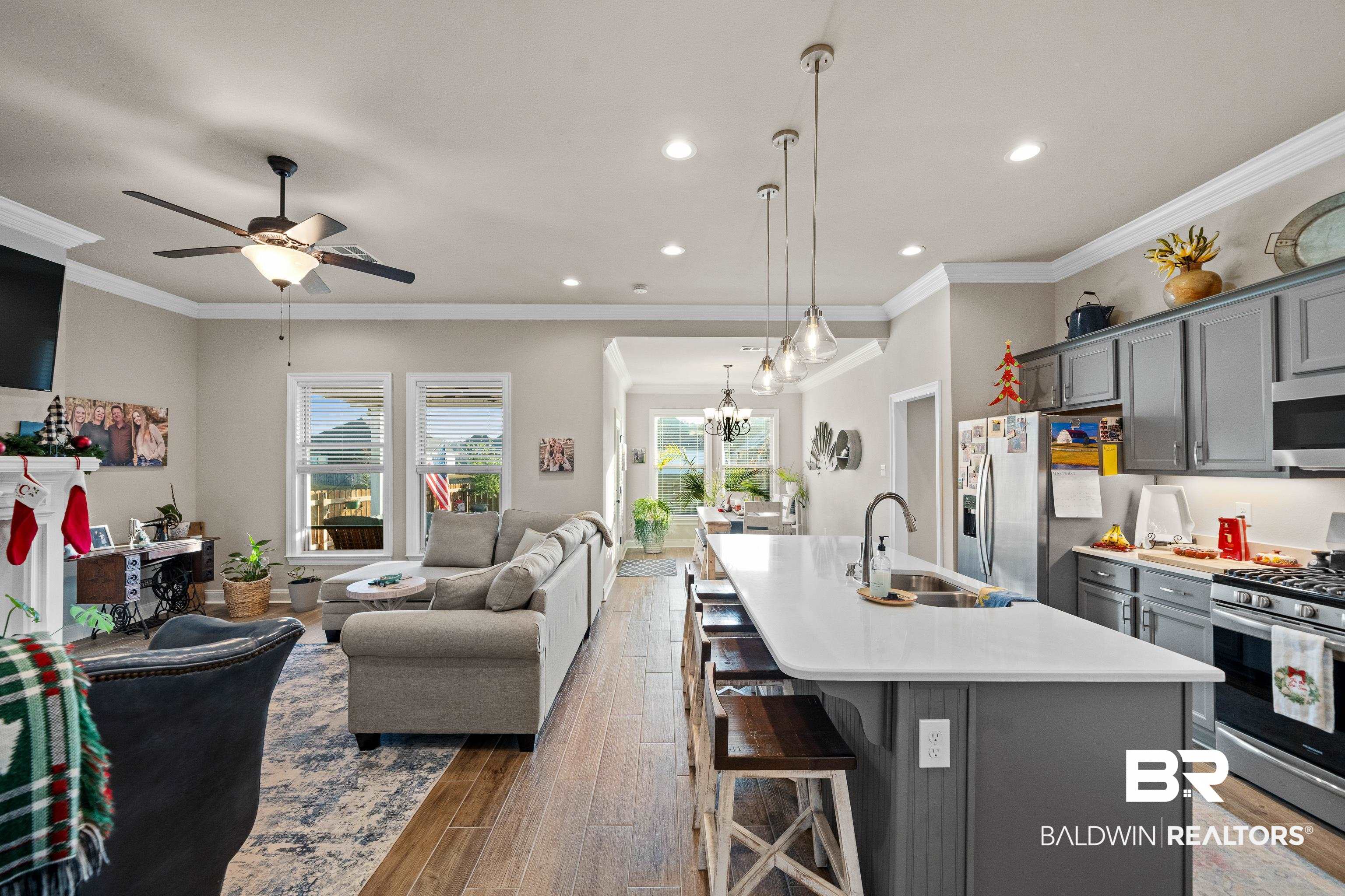 1390 Aldon Street Foley, AL 36535 - Photo 30 of 31 Kitchen featuring gray cabinets, a breakfast bar, appliances with stainless steel finishes, a kitchen island with sink, and open floor plan