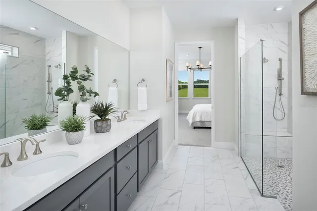 a bedroom with a large bed and a chandelier