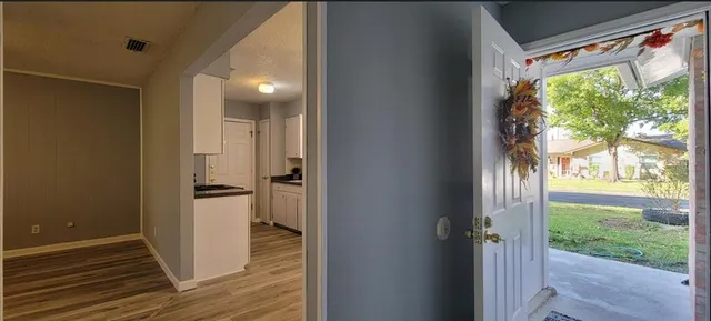 a view of a room with wooden floor and windows