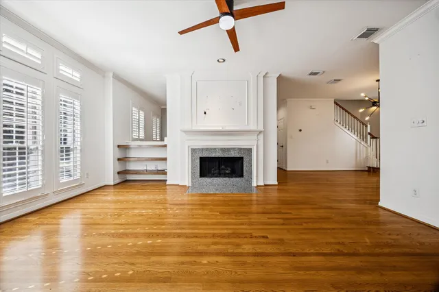 a view of kitchen and empty room with wooden floor