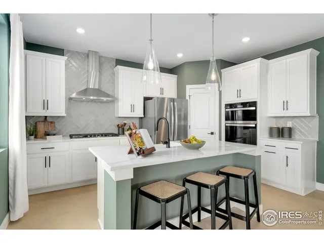 a kitchen with stainless steel appliances a table chairs refrigerator and cabinets